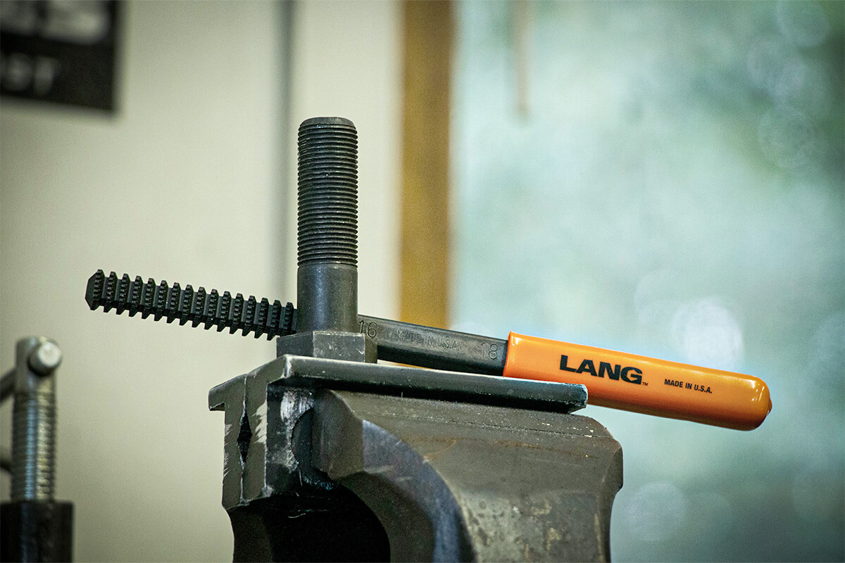 On large diameter threads, a thread file, a vise, and a good attitude will go pretty far. Large diameter taps and dies are prohibitively expensive.